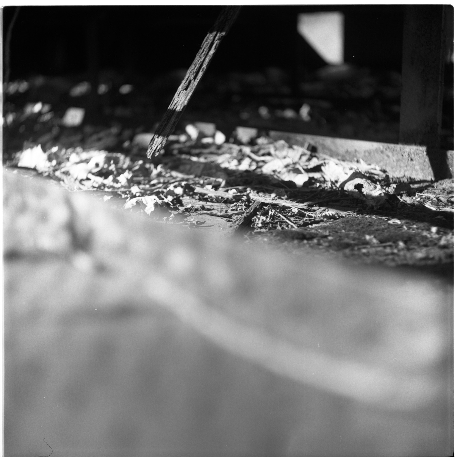 A low view beneath a decaying structure with a beam suspended above debris